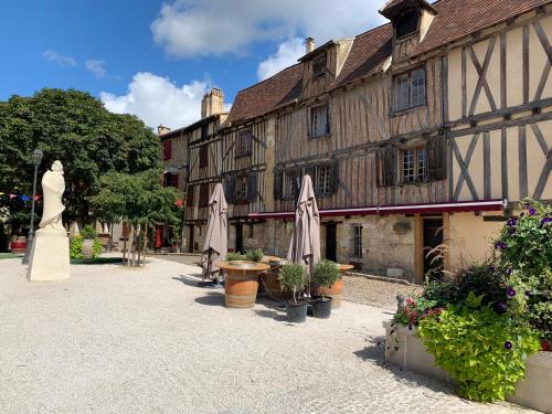 un bâtiment avec une statue d'une femme dans une cour dans l'établissement Un petit cocon verdoyant, à Bergerac