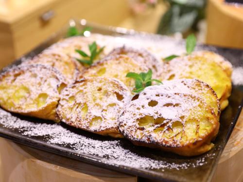 four donuts covered in powdered sugar on a plate at Dormy Inn Kawasaki Natural Hot Spring in Kawasaki