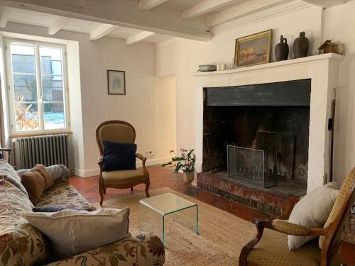 a living room with a couch and a fireplace at Gîte de groupe agritourisme 3 gîtes mitoyens 25 couchages Convivialité et intimité in Lingèvres