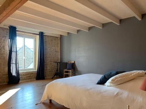 a bedroom with a large white bed and a window at Gîte de groupe agritourisme 3 gîtes mitoyens 25 couchages Convivialité et intimité in Lingèvres