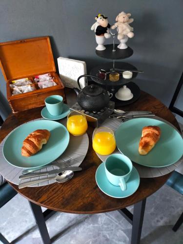 a table with plates of food and cups and croissants at Chambre d'hôtes Se Sentir Libre Châtaigne in Crozant