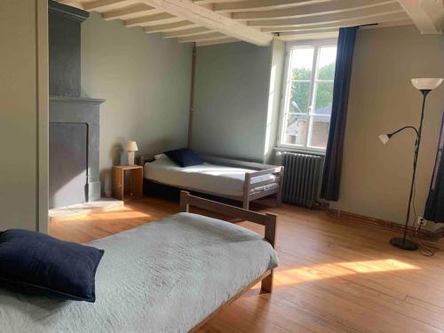 a bedroom with two beds and a fireplace and a window at Gîte de groupe agritourisme 3 gîtes mitoyens 25 couchages Convivialité et intimité in Lingèvres