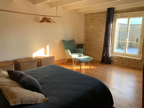 a bedroom with a bed and a chair and a window at Gîte de groupe agritourisme 3 gîtes mitoyens 25 couchages Convivialité et intimité in Lingèvres