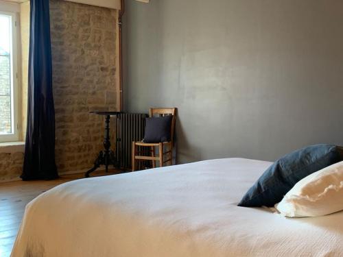 a bed with two pillows on it in a bedroom at Gîte de groupe agritourisme 3 gîtes mitoyens 25 couchages Convivialité et intimité in Lingèvres