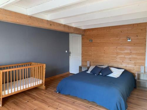 a bedroom with a blue bed and a crib at Gîte de groupe agritourisme 3 gîtes mitoyens 25 couchages Convivialité et intimité in Lingèvres
