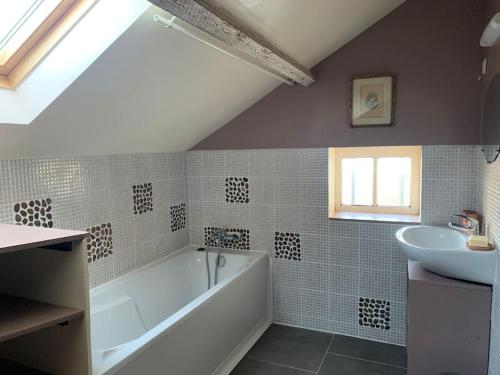 a bathroom with a white tub and a sink at Gîte de groupe agritourisme 3 gîtes mitoyens 25 couchages Convivialité et intimité in Lingèvres