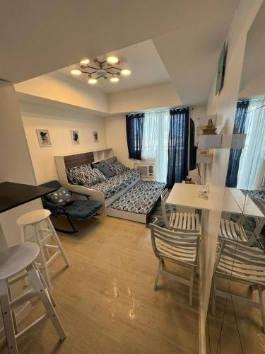 een woonkamer met 2 bedden en een tafel bij Gellybean Homestay ( AZURE North Residence / Staycation) in San Fernando