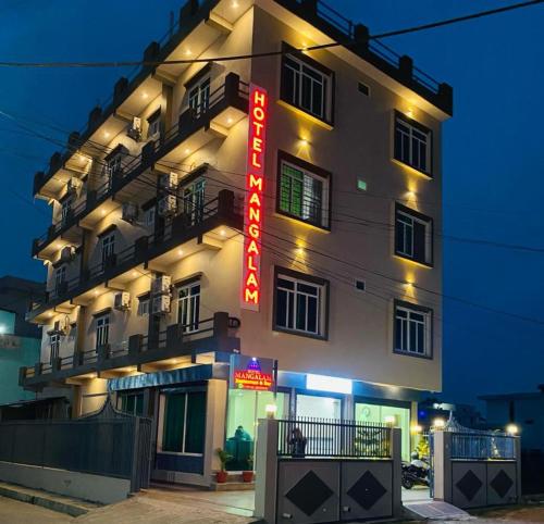 um hotel com um letreiro de néon em frente em Hotel Mangalam em Bhairahawa