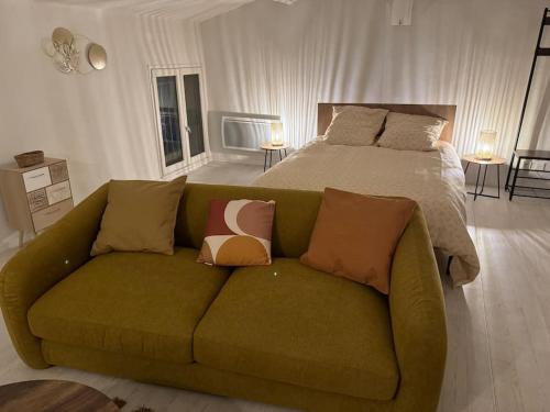 a green couch in a bedroom with a bed at Carpentras cosy& 3 voyageurs& in Carpentras
