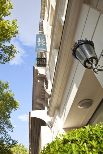 a sign on the side of a building with a street light at Trianon Gare de Lyon in Paris