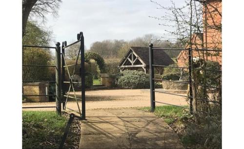 an open gate with a house in the background at Wethele Manor in Leamington Spa