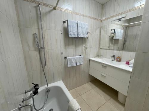 uma casa de banho com um chuveiro, uma banheira e um lavatório. em Villa del Sole Garni em Ponte Tresa