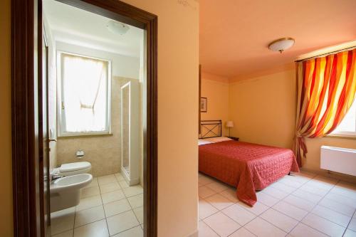 een badkamer met een slaapkamer met een bed en een wastafel bij Il Cigliere Wellness Spa Resort in Riparbella