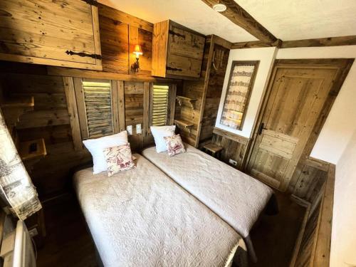 Cette chambre comprend un lit dans une cabine dotée de murs en bois. dans l'établissement Résidence Necou - Superbe appartement pour 6 personnes MAE-4594, aux Menuires