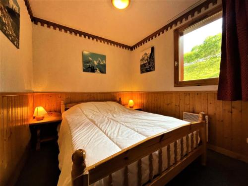- une chambre avec un lit, une fenêtre et deux lampes dans l'établissement Résidence Bosson - Appartement 6 personnes ski aux pieds MAE-4584, aux Menuires