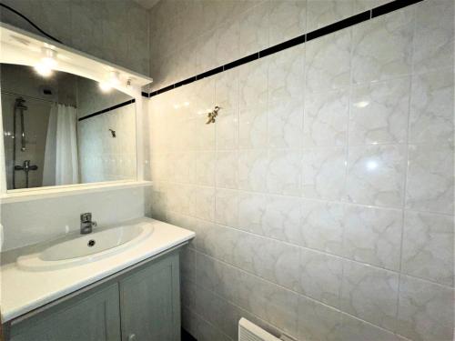 une salle de bain blanche avec un lavabo et un miroir dans l'établissement Résidence Bosson - Appartement 6 personnes ski aux pieds MAE-4584, aux Menuires