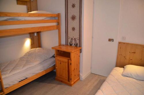 1 Schlafzimmer mit 2 Etagenbetten und einem Holztisch in der Unterkunft Résidence Chaviere - 2 Pièces pour 5 Personnes 924 in Les Menuires