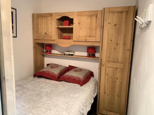 - une chambre avec un lit et des placards en bois dans l'établissement Résidence Soldanelles - Charmant appartement 4 pers aux pieds des pistes - Menuires MAE-5504, aux Menuires