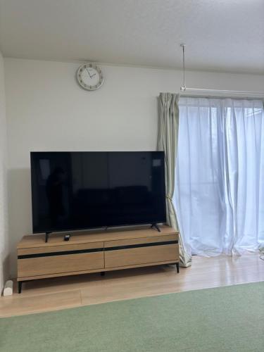 a flat screen tv sitting on a stand in a living room at 広々とした新築戸建 八街駅から徒歩10分車3台駐車可4LDK Free wifi in Yachimata