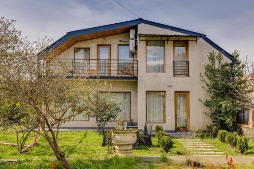 une maison ancienne avec une véranda et un arbre dans l'établissement Isev Kvareli, à Kvareli