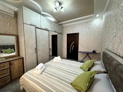 een slaapkamer met een groot bed met groene kussens bij OS Rill in Samarkand