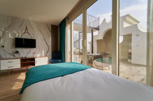 a bedroom with a bed and a tv and a balcony at Top pyramids hotel in Cairo