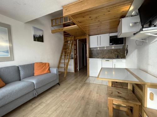 un salon avec un canapé et une cuisine dans l'établissement Résidence Dorons - Studio avec mezzanine pour 2 personnes avec balcon exposé Sud MAE-5784, aux Menuires