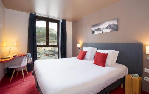 Habitación de hotel con cama grande y ventana en SOWELL HOTELS Le Parc & Spa en Briançon
