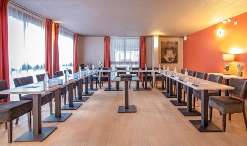 a row of tables and chairs in a room at SOWELL HOTELS Le Parc & Spa in Briançon