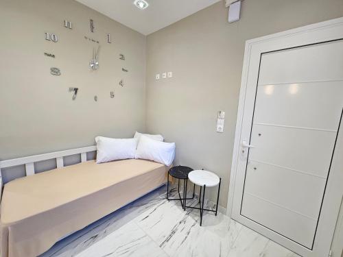a small bedroom with a bed and a clock on the wall at Evelina Luxury Suites in Corfu in Ýpsos