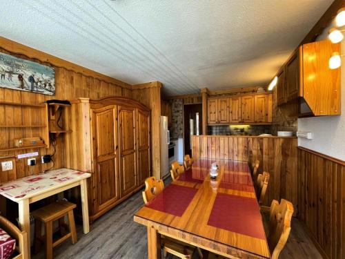 une salle à manger avec une table et des chaises en bois dans l'établissement Résidence Tougnette - Appartement pour 4 personnes avec balcon exposé Sud MAE-6864, aux Menuires