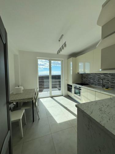 a kitchen with a table and a large window at Sunrise paradise in Suceava