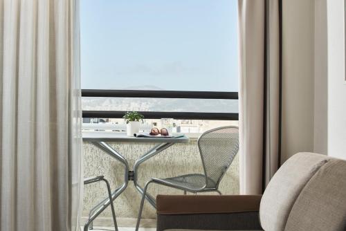 a balcony with a table and chairs in a room at Novotel Athens in Athens