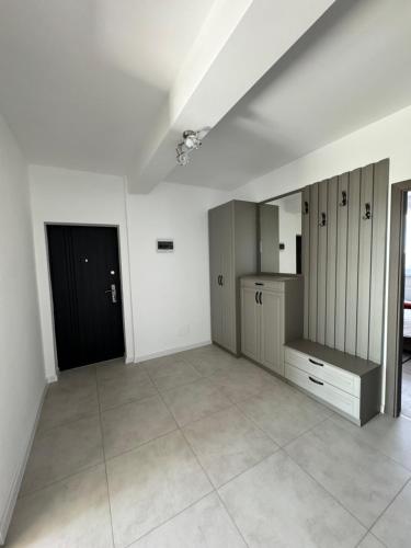 ein leeres Zimmer mit einer Küche und einer schwarzen Tür in der Unterkunft Sunrise paradise in Suceava