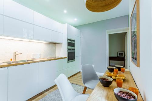 une cuisine et une salle à manger avec une table et des chaises en bois dans l'établissement Maison Bianchi - Biscarra, à Nice