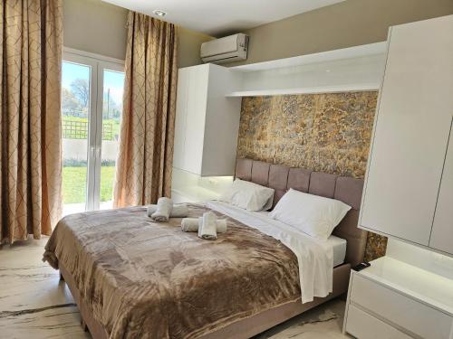 a bedroom with a large bed with two towels on it at Evelina Luxury Suites in Corfu in Ýpsos