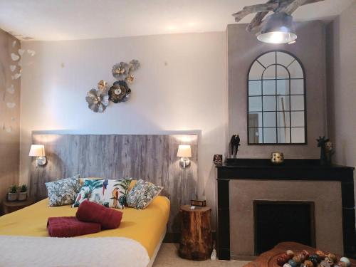 a bedroom with a bed with a fireplace and a mirror at Au coeur d'un cocon.... in Pennautier