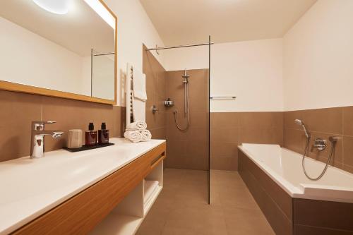 y baño con bañera, lavamanos y ducha. en Landhaus Antonius, en Appiano sulla Strada del Vino