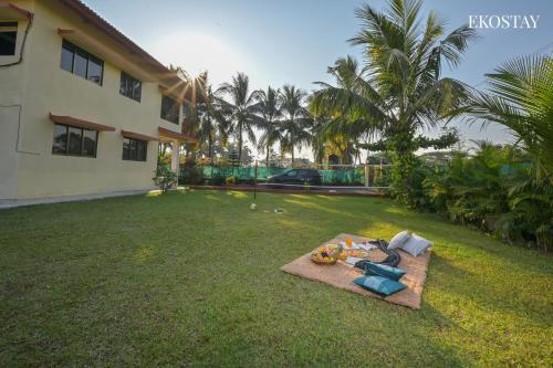 a yard of a house with a bunch of food on the grass at EKOSTAY - Bloomfield Villa in Alibaug