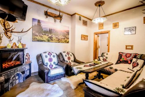 a living room with two chairs and a fireplace at Domek u Zosi in Zakopane