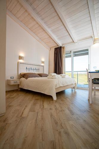 a bedroom with a large bed and a large window at Rena Majore Country Resort in Lampianu