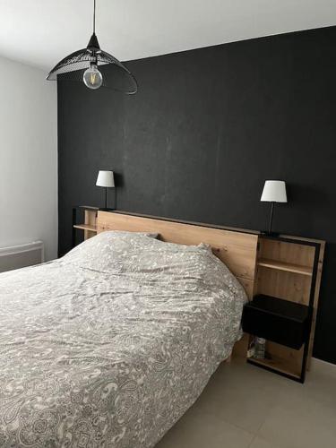 - une chambre avec un lit et un mur noir dans l'établissement Appartement neuf, climatisé, piscine, terrasse, à La Londe-les-Maures