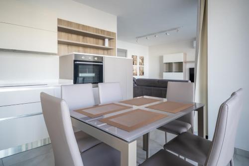 een keuken en eetkamer met een tafel en stoelen bij Seabreeze Luxury Apartment in St Paul's Bay