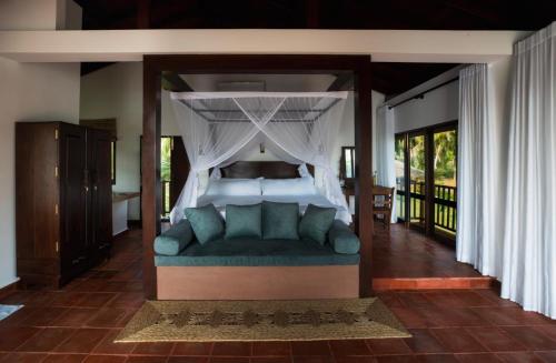 a bedroom with a bed with a canopy at Village Paradise in Beliatta