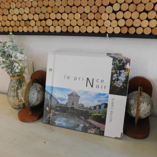 a book sitting on top of a table with vases at Logis Hotel Le Prince Noir in Sérignac-sur-Garonne