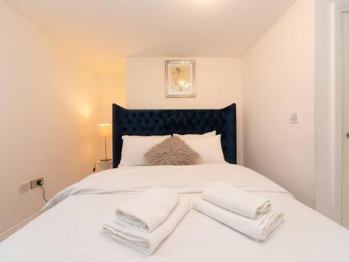 a white bed with two white towels on it at Pass the Keys Cosy 2 Bed Flat in London in a Historic Building in London
