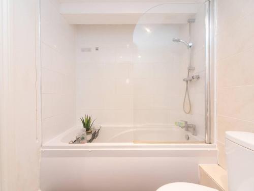 a white bathroom with a tub and a toilet at Pass the Keys Cosy 2 Bed Flat in London in a Historic Building in London