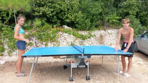 twee mensen die rond een tafeltennistafel staan bij Camping La Scogliera - Maeva Vacansoleil in Castro di Lecce
