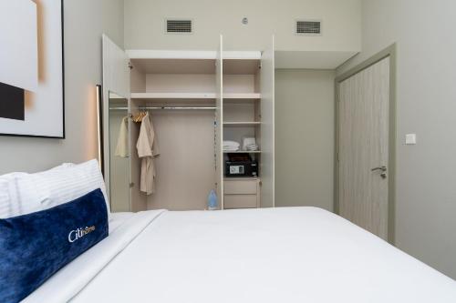 1 dormitorio con cama blanca y armario en CitiHome - Newly Furnished Apartment in Business Bay, en Dubái