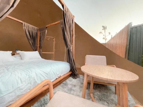 a bedroom with a canopy bed and a table at The X10 Glamping Pool Villa Khaoyai เขาใหญ่ - SHA Certified in Pak Chong